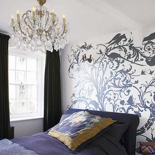 bedroom with grey bed and floral wallpaper