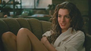 Anne Hathaway in a white button-down on a couch in a still from love and other drugs