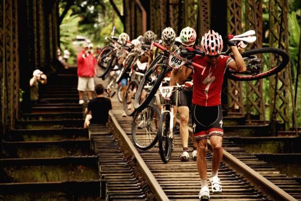 The lead elite men walk a bridge