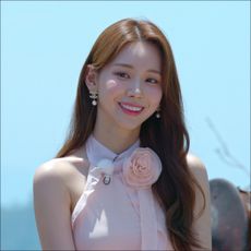 a woman with a pink flower top smiling