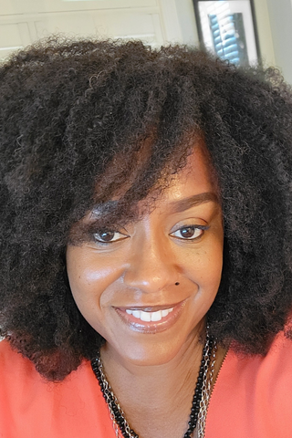 Darlese Robinson wearing Bobbi Brown's concealer stick in a coral top.