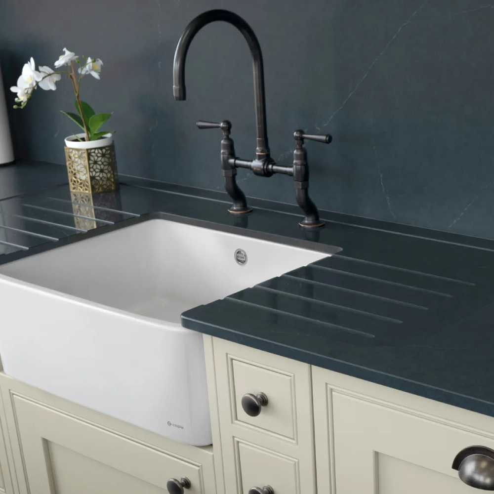white belfast sink inset in black worktop on cream units