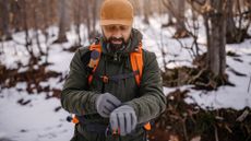 Best cold weather gloves: Man in warm clothing on winter hiking tour
