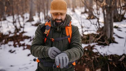 Best cold weather gloves: Man in warm clothing on winter hiking tour