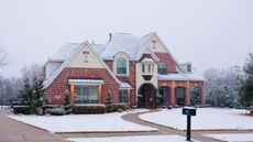 A house covered in snow with ice cleared from the path and driveway