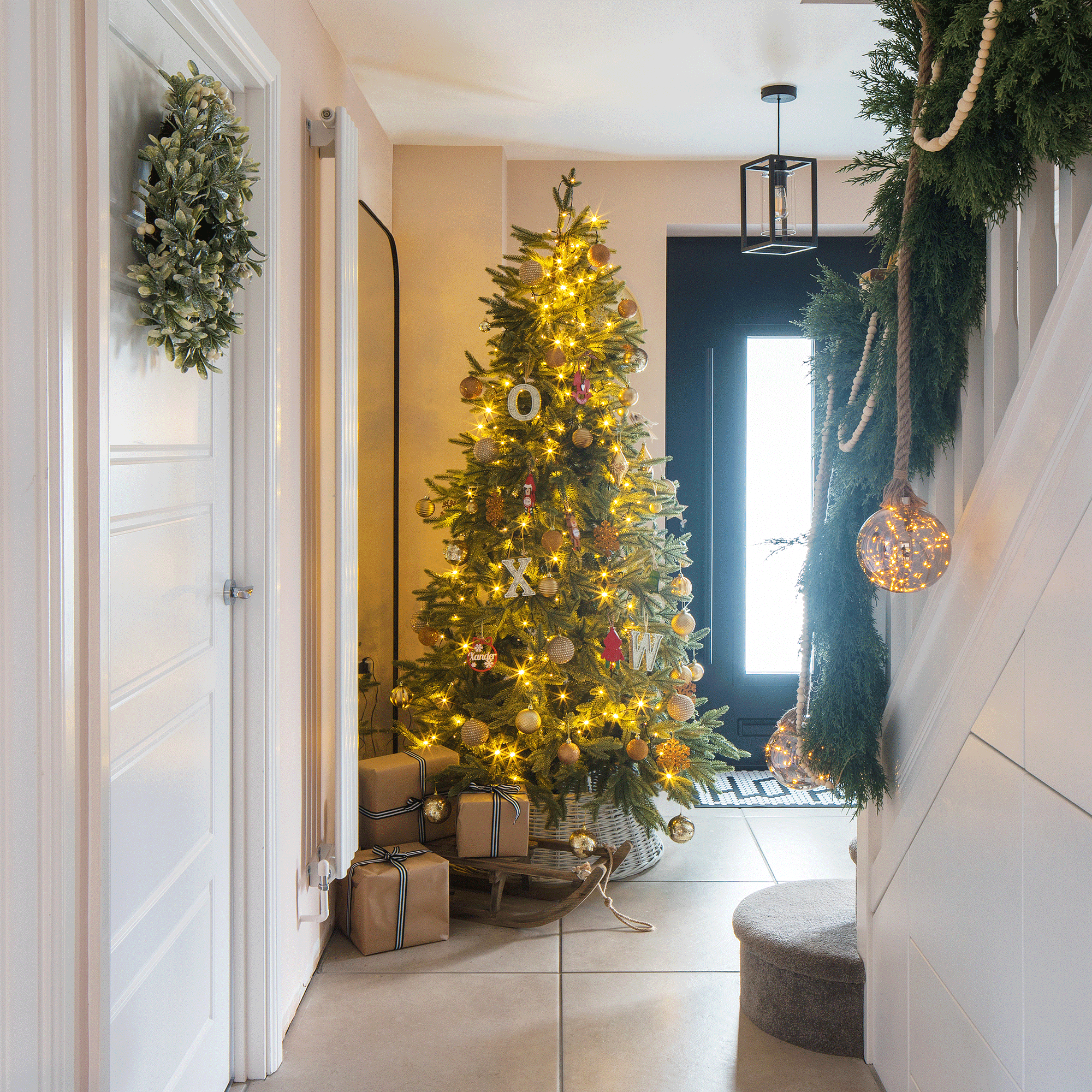 a hallway with a christmas tree beside the front door