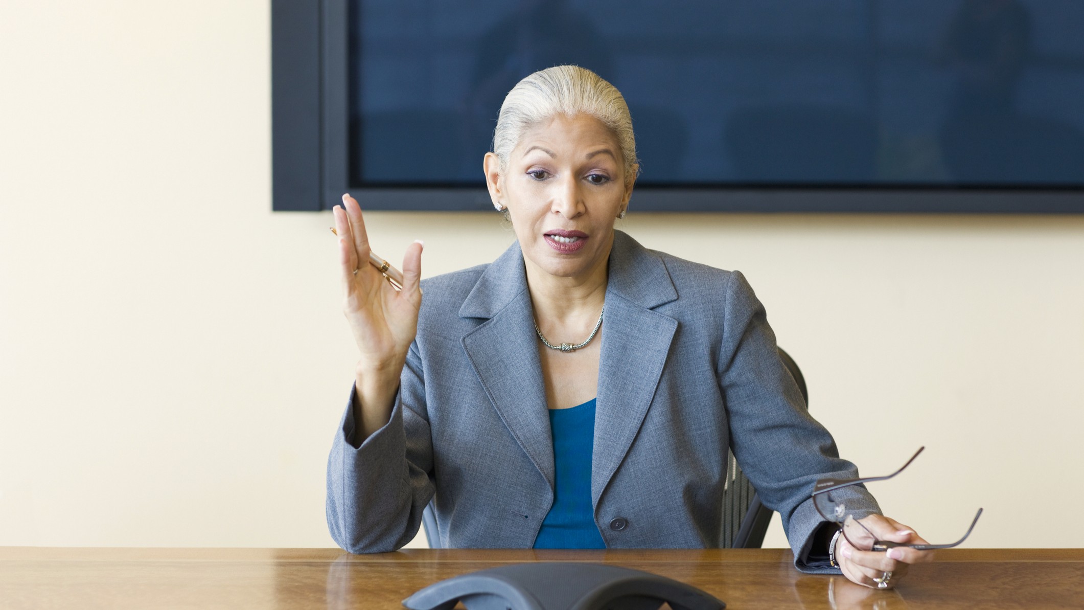 An older businesswoman or professional talks during a meeting.