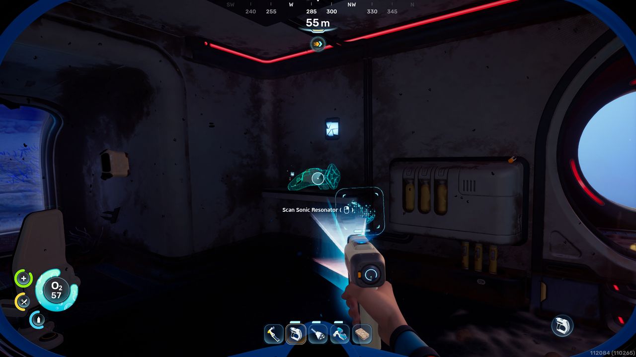 Subnautica 2 mining: A player looking at a Sonic Resonator fragment they can scan inside a dark habitat.