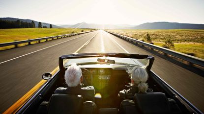 picture of elderly couple driving down a road in the country