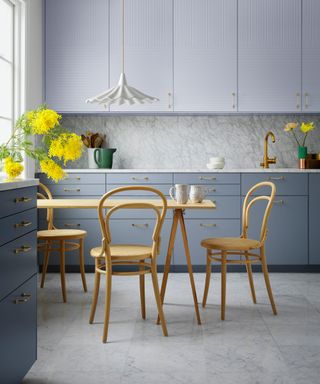 grey kitchen with yellow table and chairs and white pendant light above