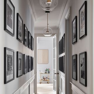 white hallway with black and white framed prints