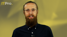 Presenter Ant Joblin wearing a black shirt in front of a yellow background