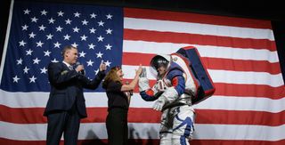 NASA Administrator Jim Bridenstine, left, gives a thumbs up as Amy Ross, a spacesuit engineer at NASA’s Johnson Space Center, center, high fives Kristine Davis, a spacesuit engineer at NASA’s Johnson Space Center, wearing a ground prototype of NASA’s new Exploration Extravehicular Mobility Unit (xEMU), after a demonstration of the suits enhanced mobility, Tuesday, Oct. 15, 2019 at NASA Headquarters in Washington.