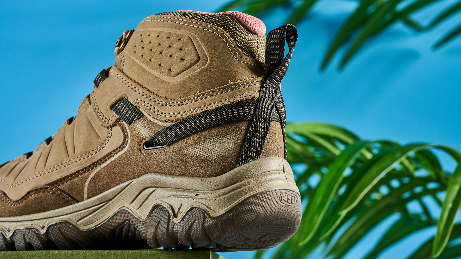 Keen Targhee IV hiking boots photographed in front of a blue background.