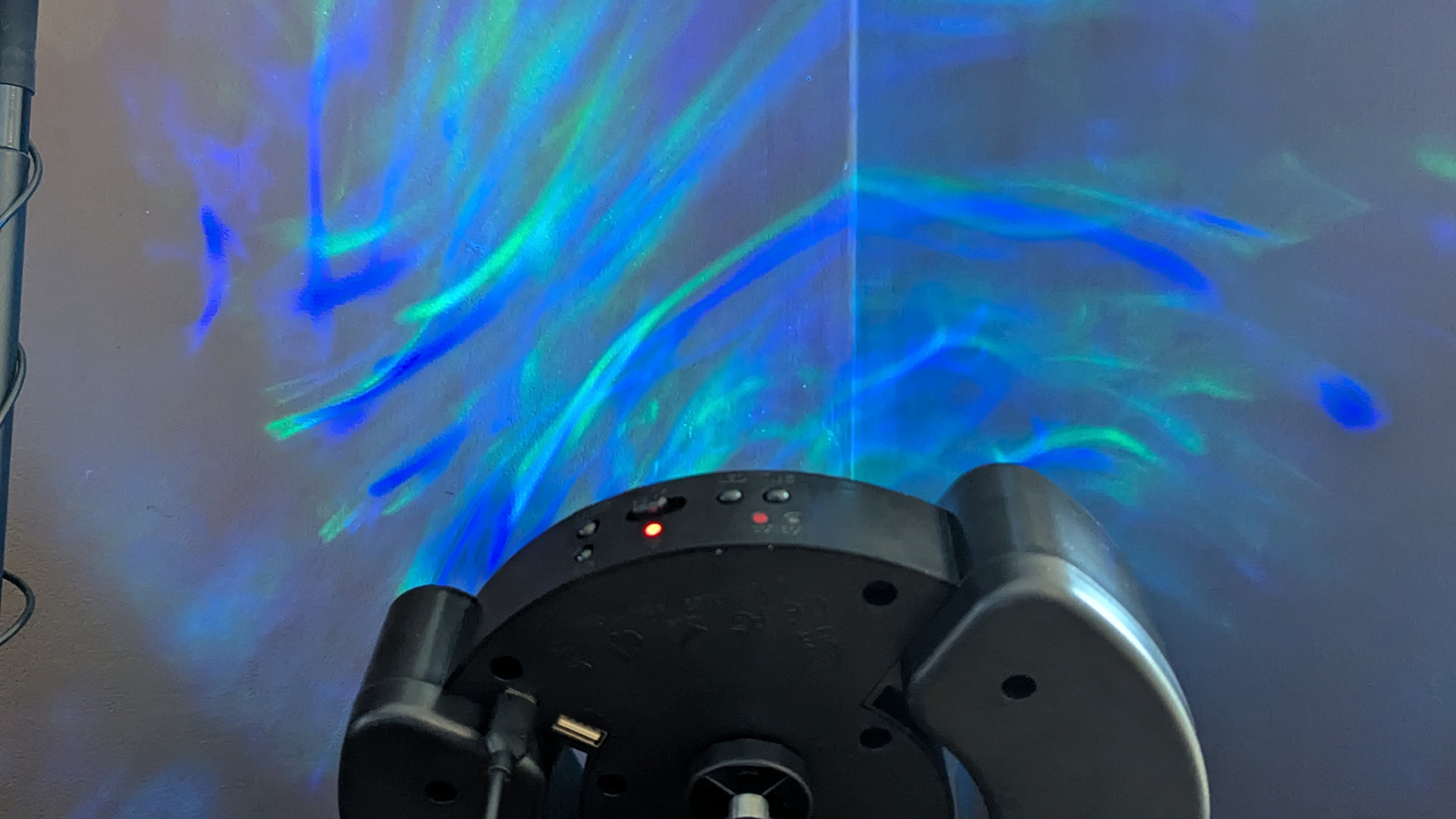 YgiTK Northern Galaxy Lights Projector during Review, on a wooden table against a dark coloured wall