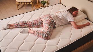 A person lies in a stomach sleeping position on the Extra Firm side of the Plank FIrm mattress