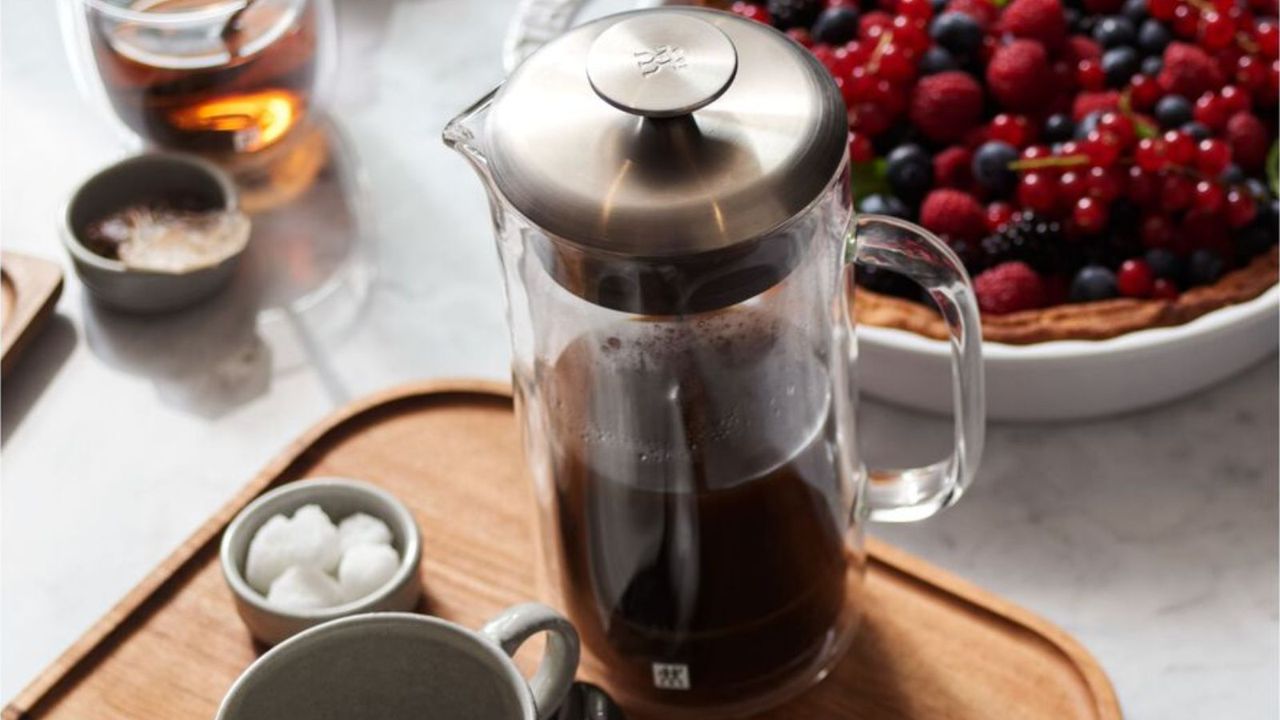 Zwilling Sorrento Plus French press on a wooden board with cups of coffee around it and a berry tart in the background