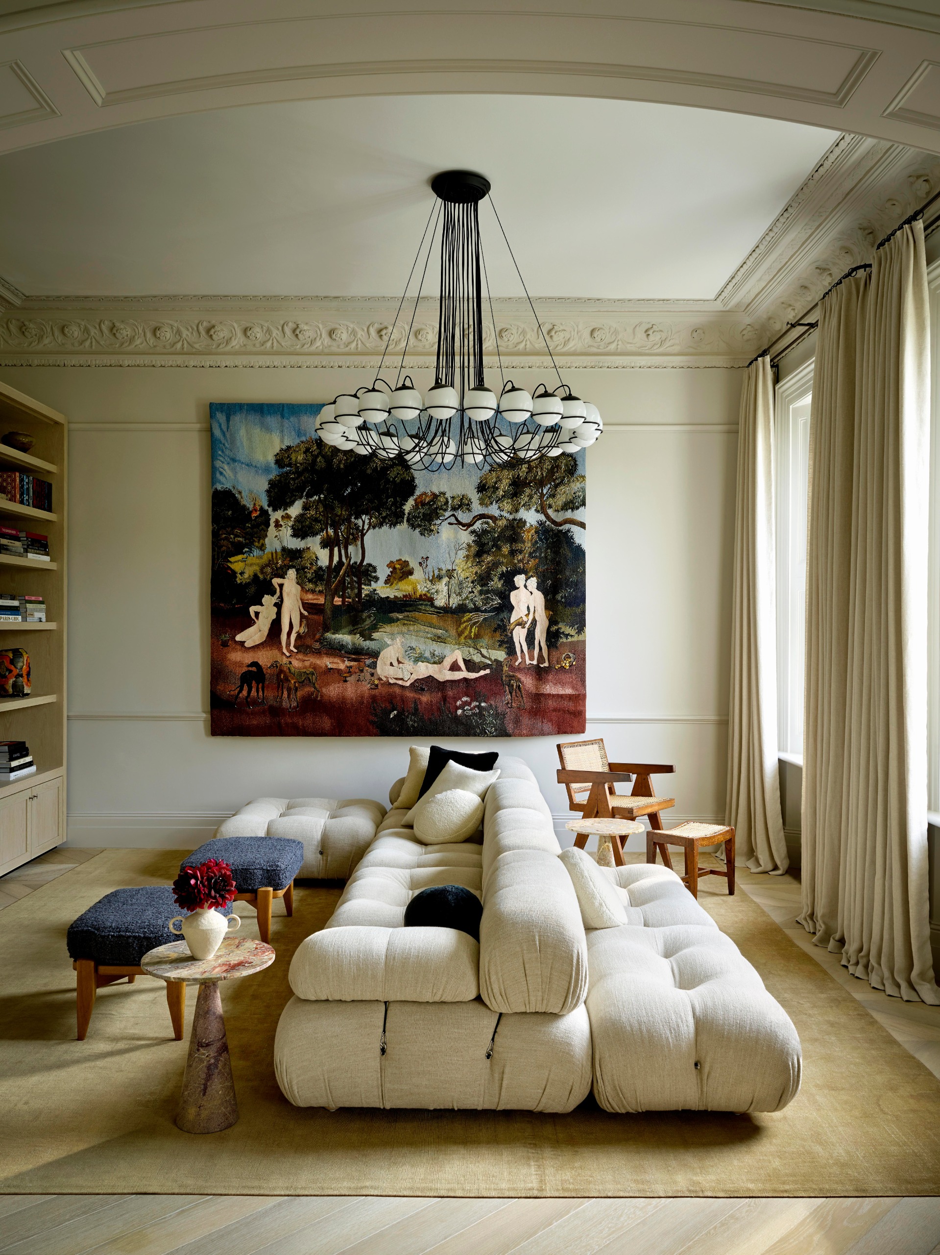 Beautifully decorated interiors with pastel-toned walls, sculptural seating, statement lighting, wood furniture upholstered in colorful fabric, and lots of natural light.