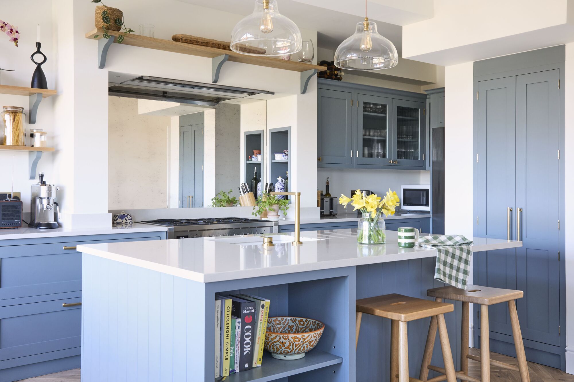 A kitchen with blue inset cabinetry and white countertops