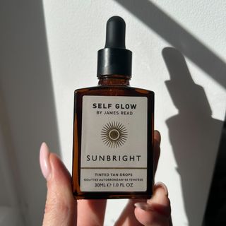 Hand holding Self Glow by James Read Sunbright Face Tan Drops