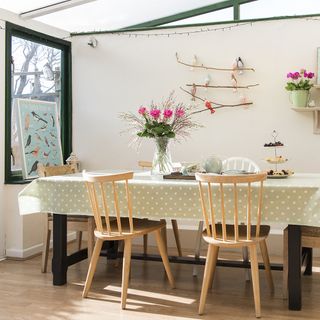 dining room with white wall and wooden flooring with dining table and wooden chair