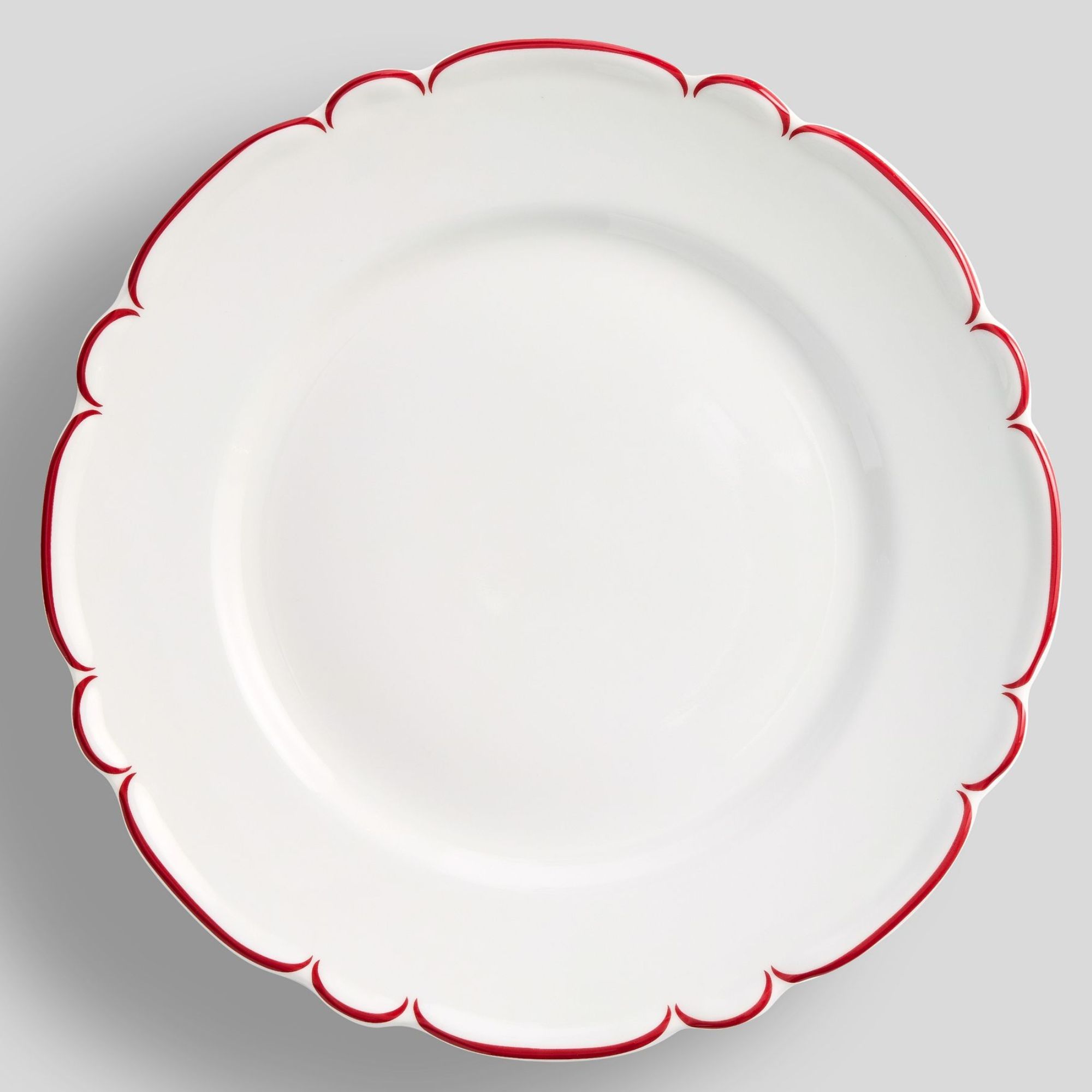 White dinner plate with scalloped red rim
