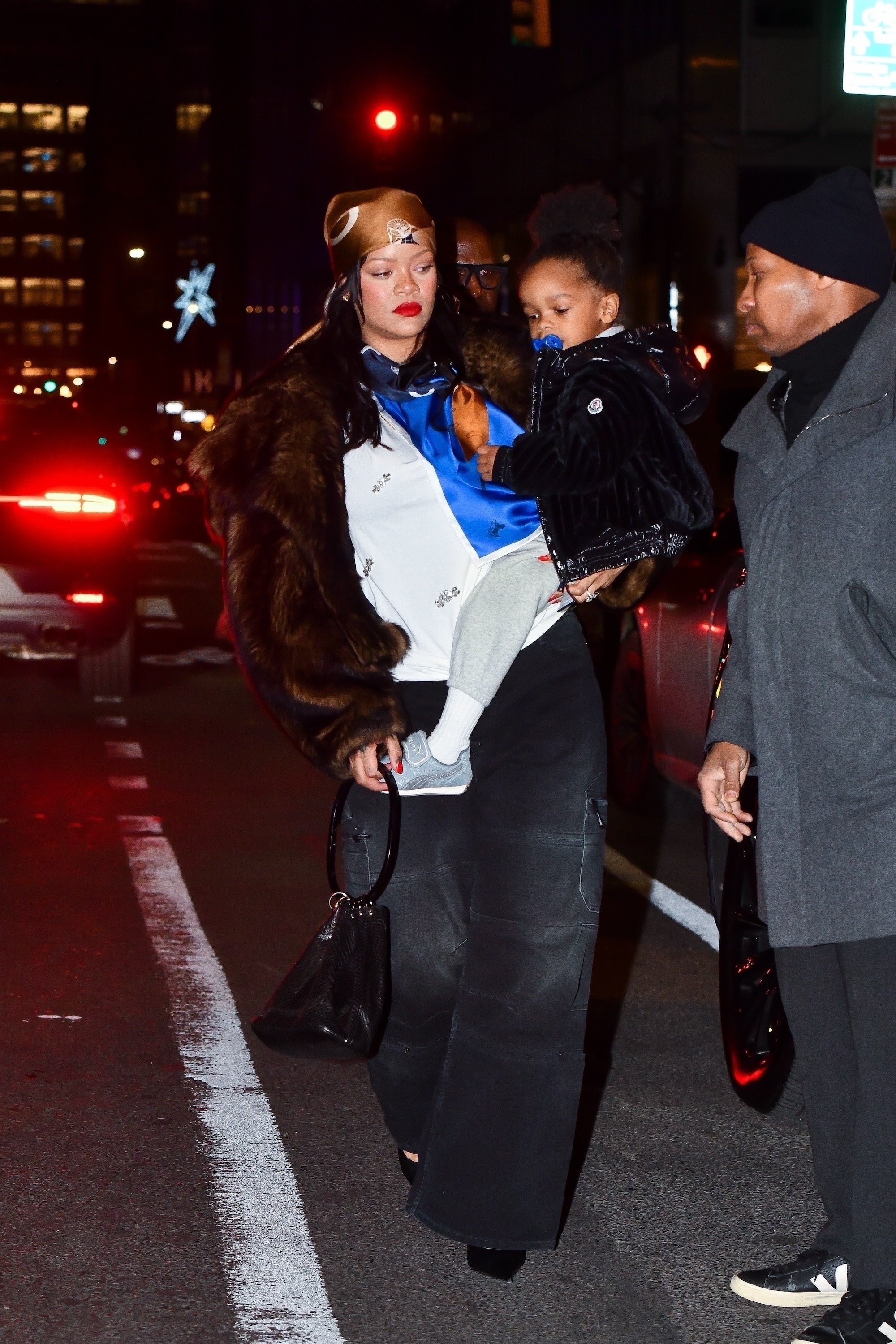 Rihanna was spotted in NYC wearing cargo pants, a fur coat, a silk head scarf, and the single-strap bag trend