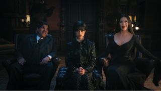 Wednesday and her parents sit in the principal's office after arriving at Nevermore Academy in Wednesday Season 1.