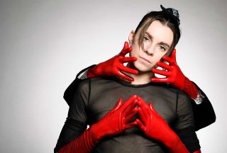 Lyndsey Gunnulfsen of the band Pvris poses for a portrait in red gloves with two other gloved hands holding her face