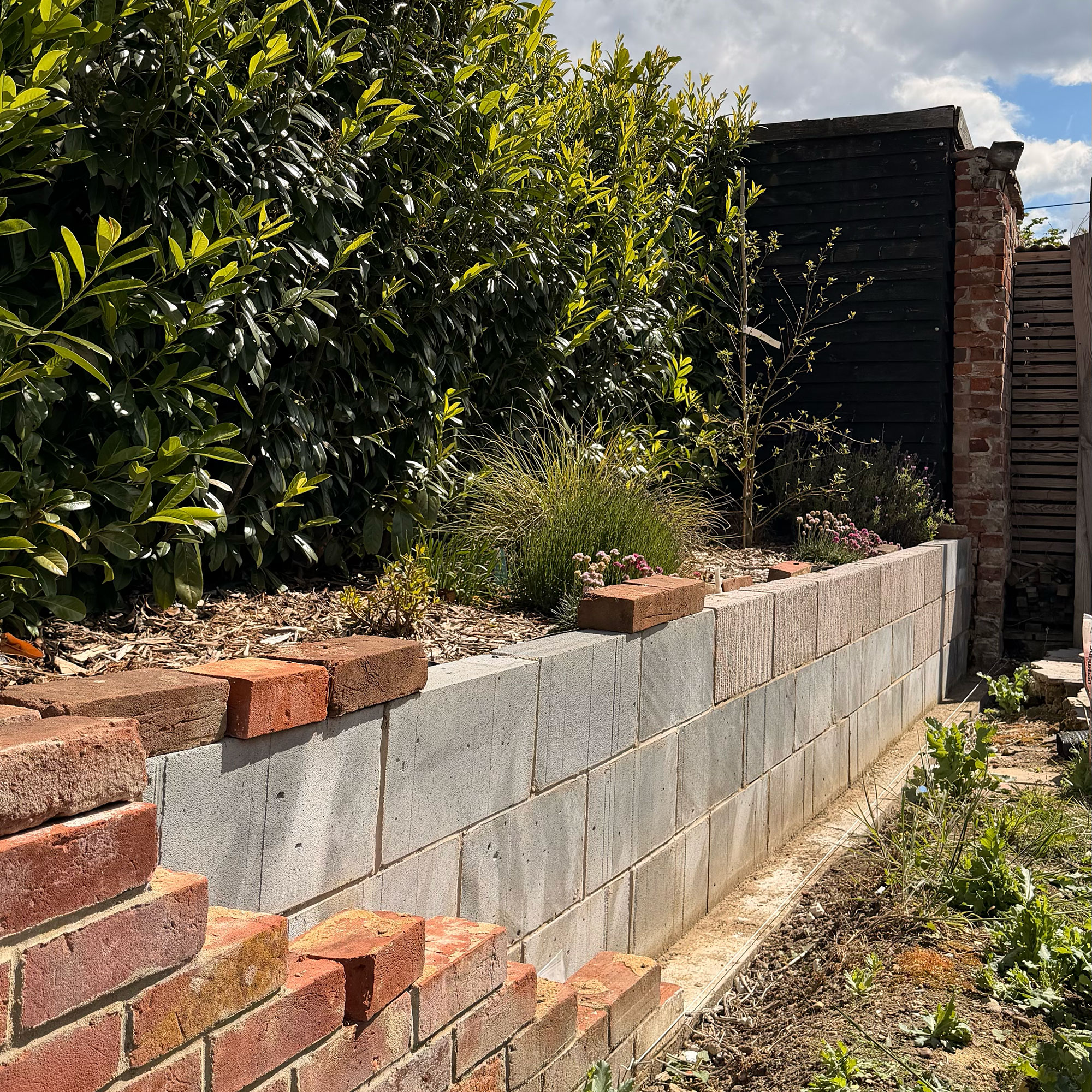 Brick garden wall mid-construction