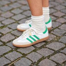 COPENHAGEN, DENMARK - FEBRUARY 01: Emili Sindlev wears white socks, white shiny leather and green logo suede sneakers from Adidas , outside OperaSport , during the Copenhagen Fashion Week Autumn/Winter 2023 on February 01, 2023 in Copenhagen, Denmark. (Photo by Edward Berthelot/Getty Images)