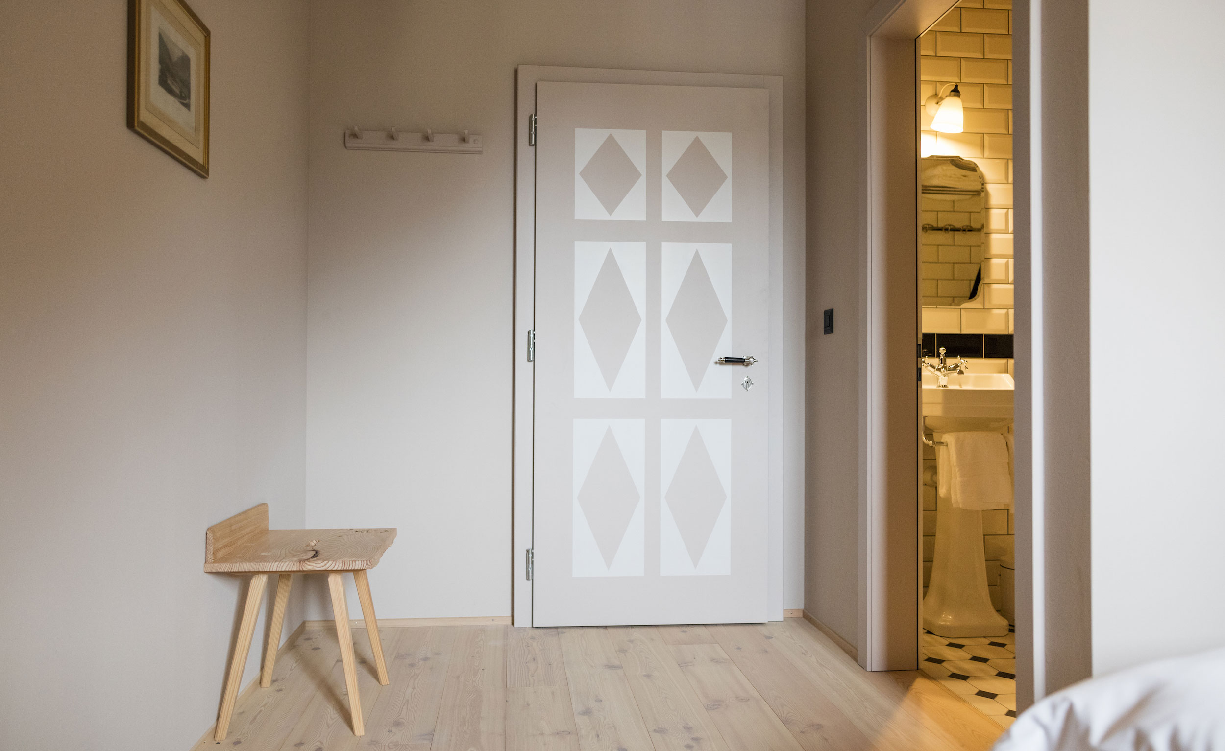 A hotel doorway, and slight view of the bathroom