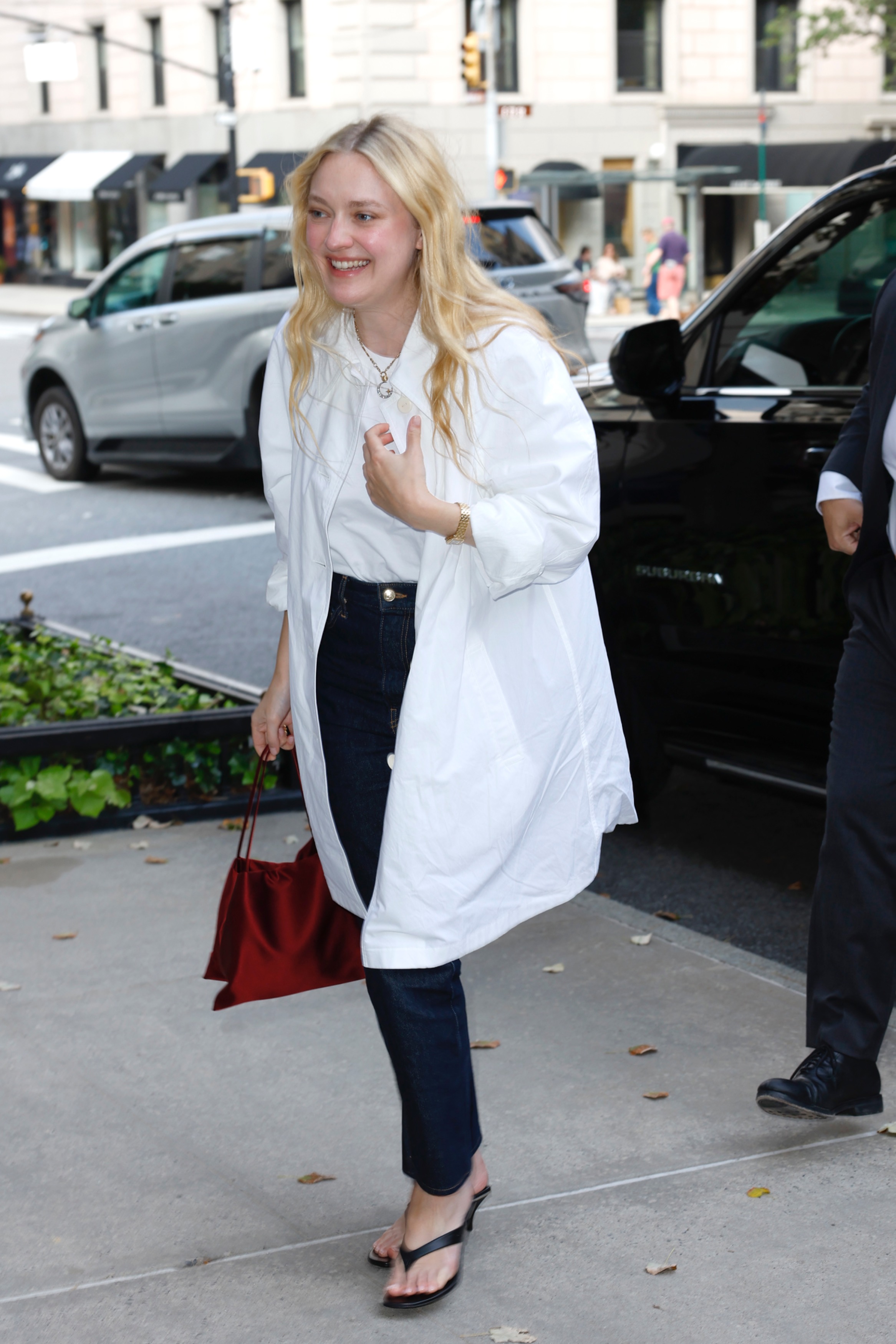 Dakota Fanning wears dark jeans, heeled flip flops, an oversize white shirt to Ralph Lauren