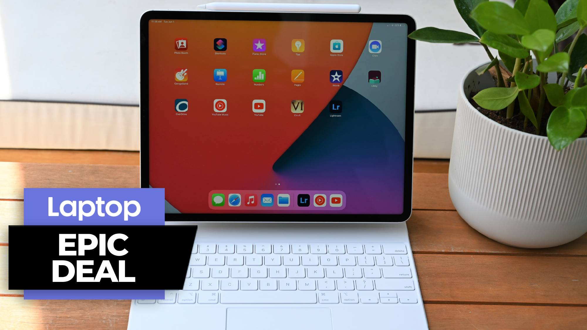 M1 iPad Pro 12.9 with Apple keyboard and Apple pencil on a wooden table next to a potted plant
