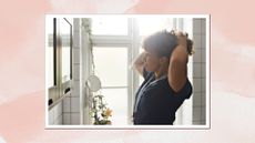 Image of woman tying up her curly hair on a pink watercolour background