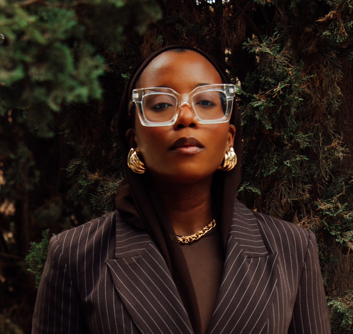 woman with big glasses and brown suit