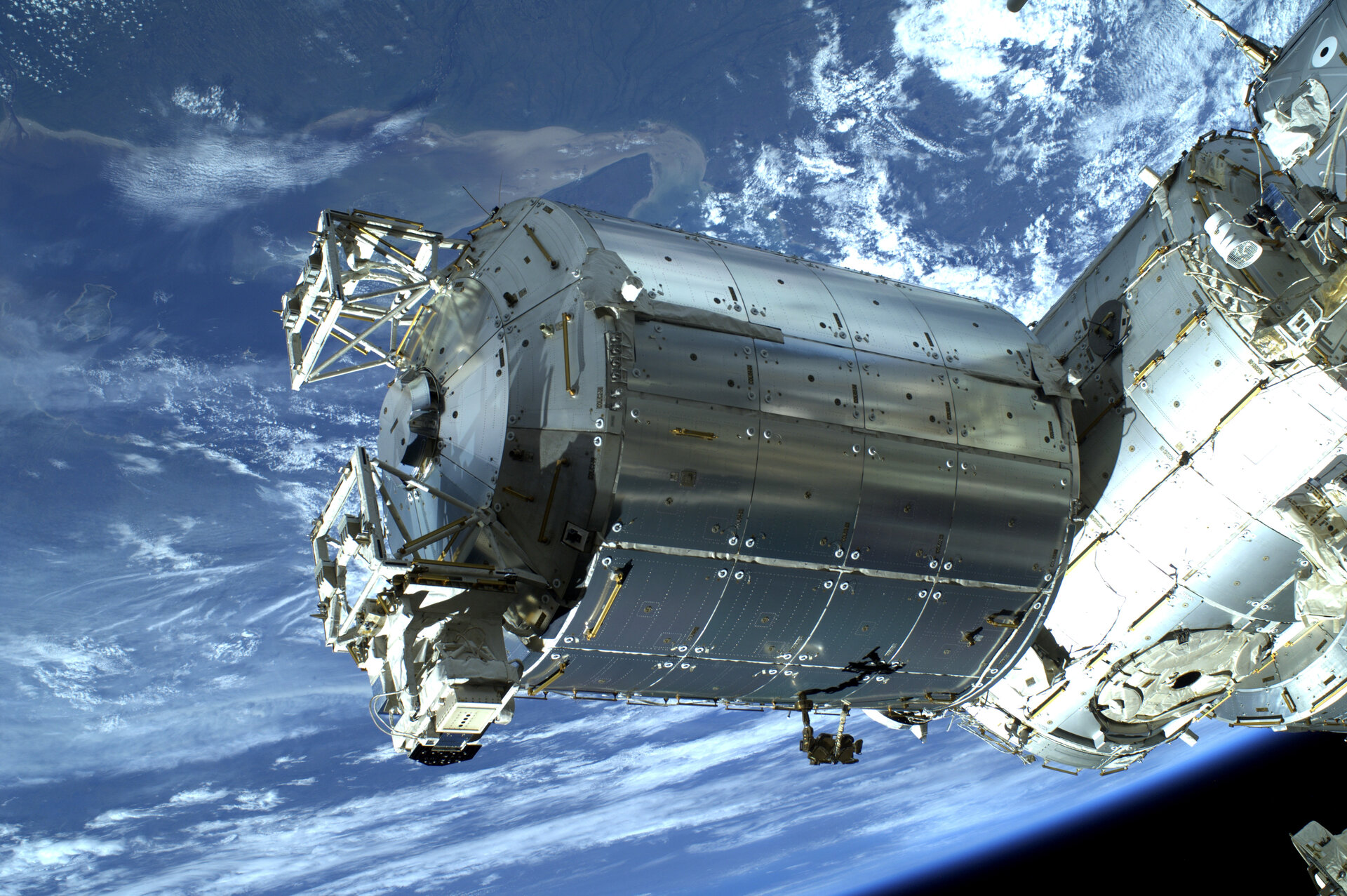 A silver european space laboratory at attached to a space station over earth