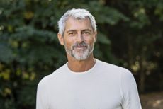 Portrait of smiling mature man standing in backyard