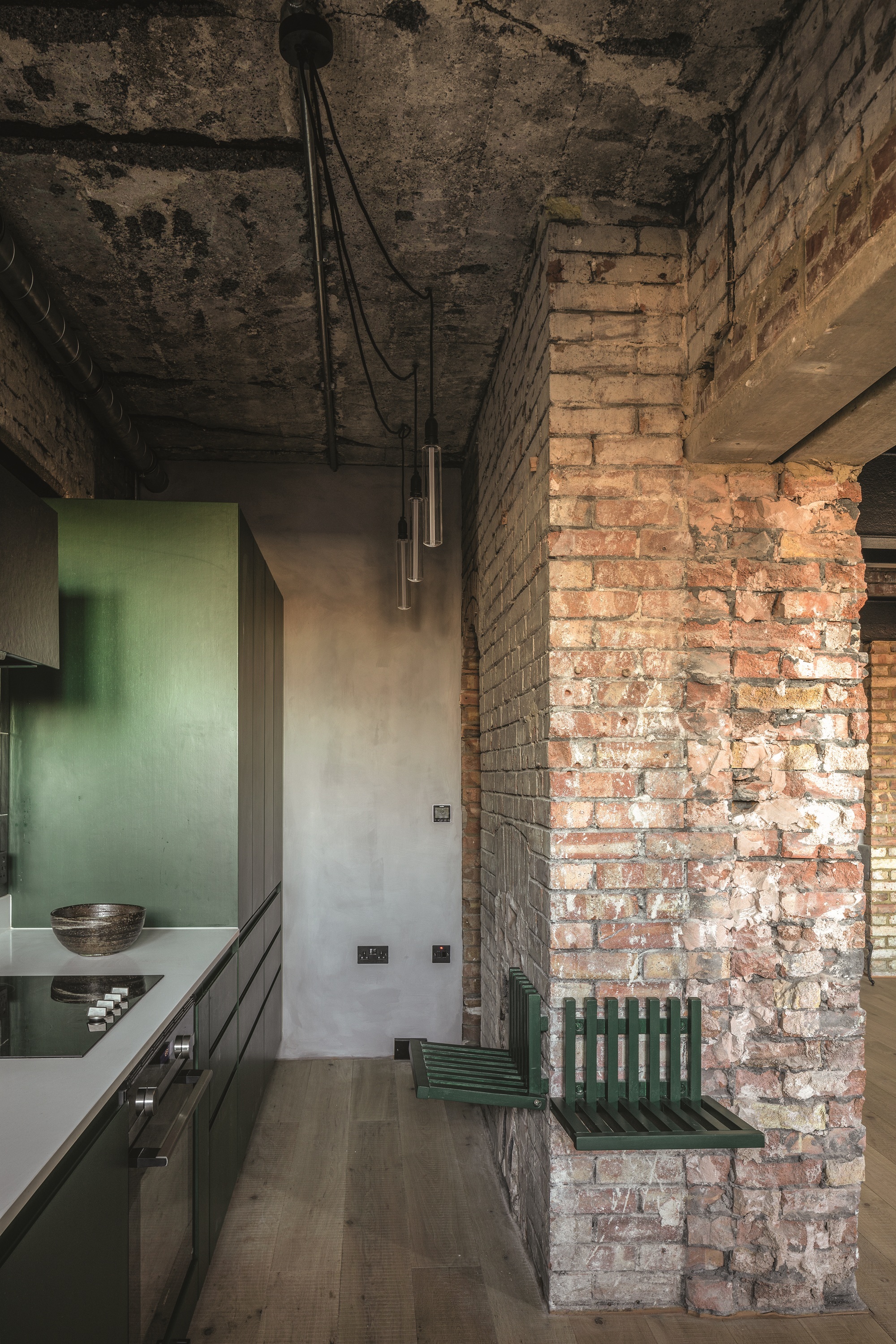 Cupboards by Puustelli, painted moss green (Ral). Quartz worktop by Silestone. Bespoke fold-down bench by Inter Urban Studios, painted moss green (Ral). GE fan table lamp.