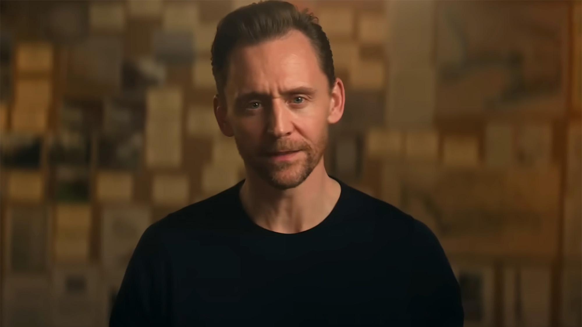 Tom Hiddleston addressing the camera with his notes in the background in Pompeii: Out of Time.