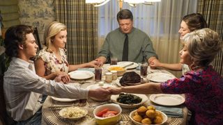 The cast of Young Sheldon holding hands around a dinner table