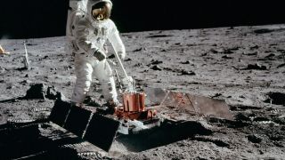 An astronaut deploying an instrument on the surface of the moon.