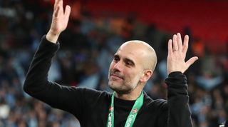 Pep Guardiola raises his arms after winning the Carabao Cup