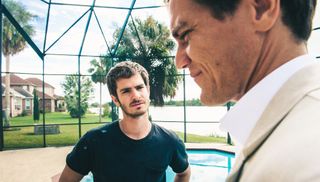 andrew garfield looks on at michael shannon in 99 homes