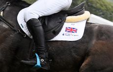 A close up of an event rider&rsquo;s leg showing the saddle and union flag on a white saddlecloth