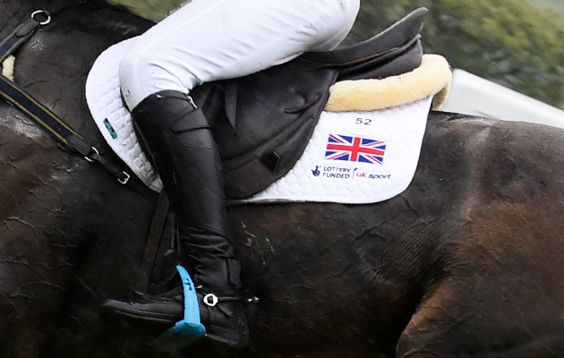 A close up of an event rider&rsquo;s leg showing the saddle and union flag on a white saddlecloth