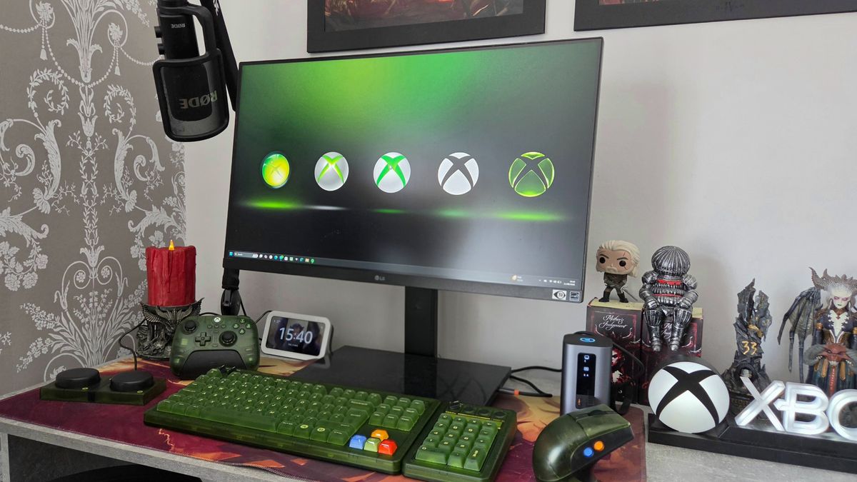 Monitor showing Xbox background, and keyboard placed on a desk