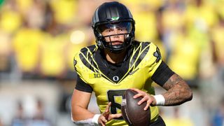 Dillon Gabriel (8) of the Oregon Ducks rolls out to throw a pass during the first half against the Illinois Fighting Illini at Autzen Stadium on October 26, 2024 in Eugene, Oregon