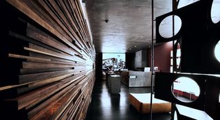 A darkly lit store features futuristic, geometrically shaped furniture and wooden wall finishes.