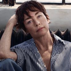 A portrait of actress Julianne Nicholson, sitting in front of a window and a radiator.